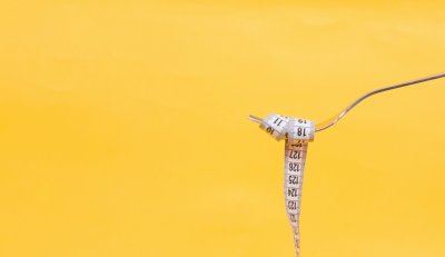 A photo of a flak with a tape measure wrapped around it to represent Eating Disorders and Diet