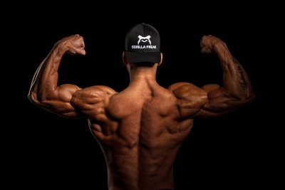 A behind view of an extremely muscular man flexing his muscles to represent Muscle Dysmorphic Disorder