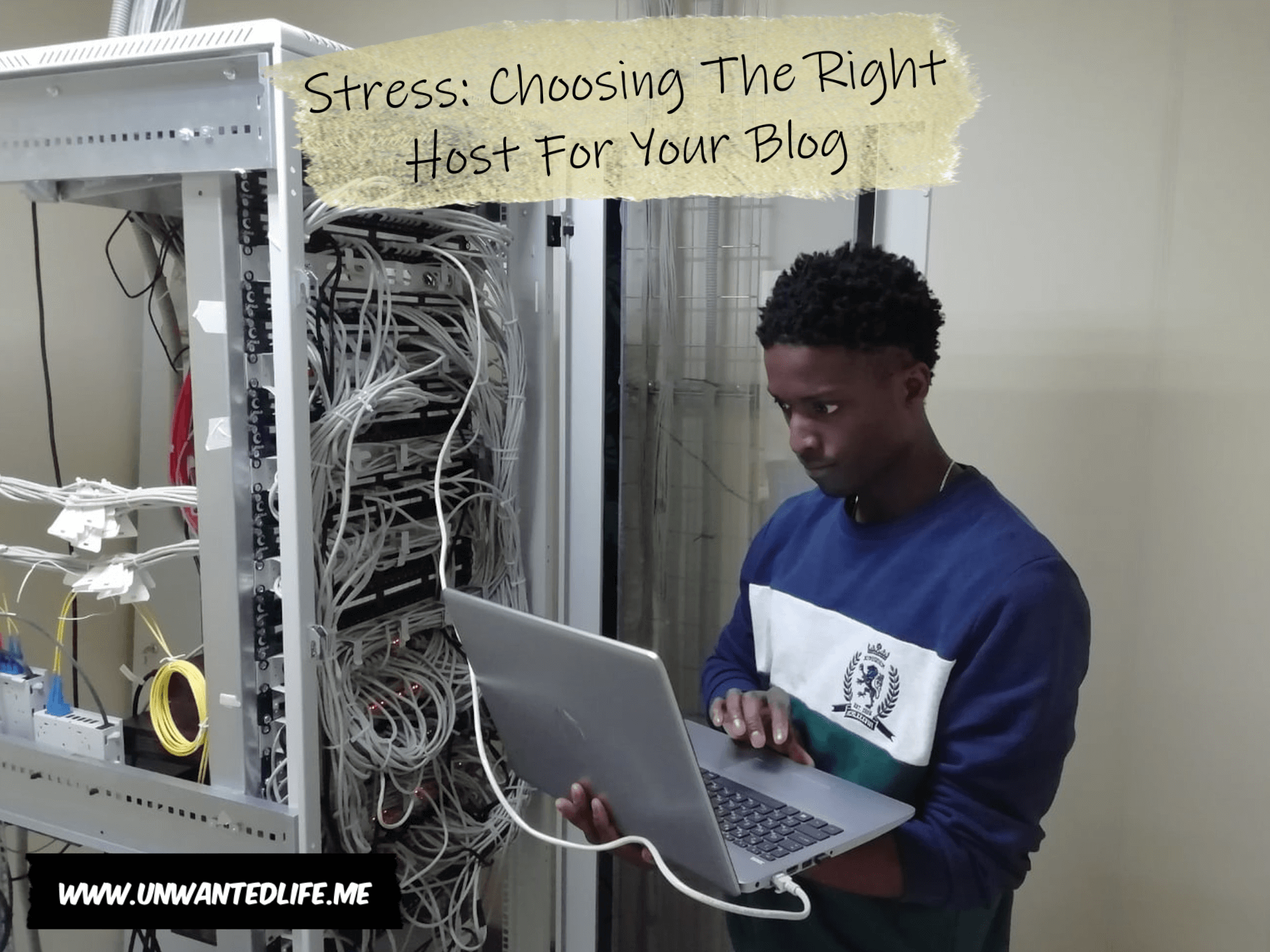 A photo of a young black man working on a laptop connected to a server hub with the article - Stress: Choosing The Right Host For Your Blog - across the top of the photo