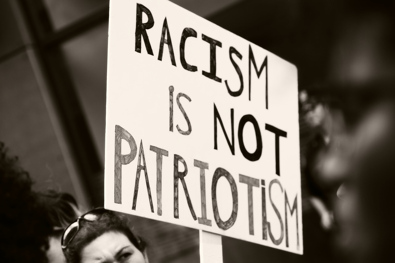 A photo of a protest placard that says "racism isn't patriotism" to represent the topic of the article - Brexit And Hate Crimes: Do You Feel Safe?