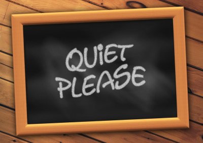 A chalkboard with "Quiet Please" wrote on it 