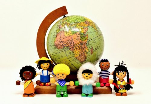A picture of the globe and a selection of dolls that look like people from all over the world to represent the topic of the story - Runt Of The Litter