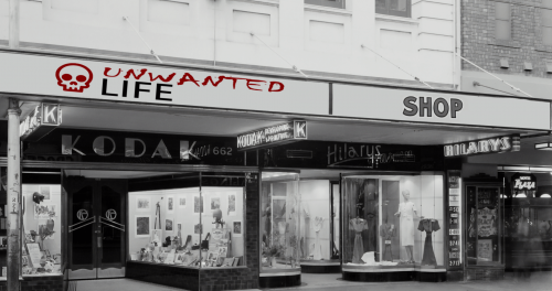 A black and white picture of a series of shops with the logo of Unwanted Life above one of the store fronts to present the shop for Unwanted Life