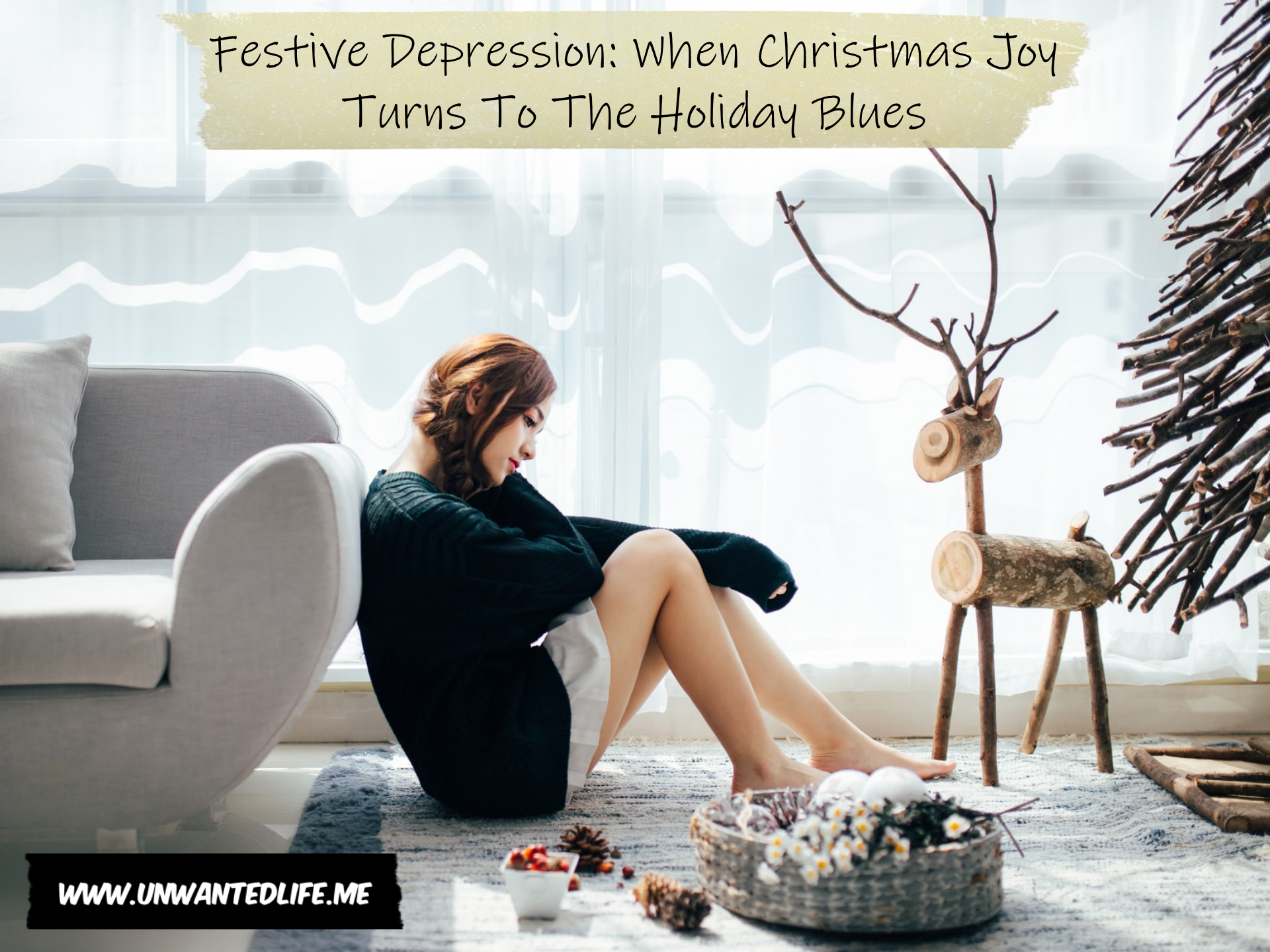 Photo of a woman of east Asian heritage sitting on the floor and resting against a sofa looking sad, with Christmas decorations in front of her to represent the topic of the article - Festive Depression: When Christmas Joy Turns To The Holiday Blues