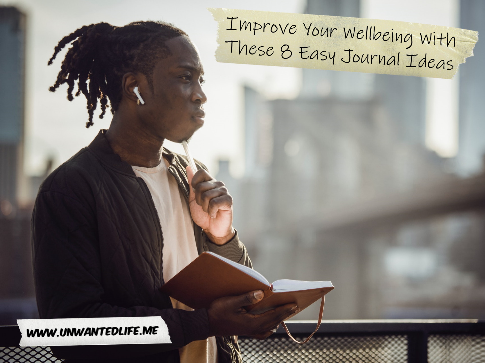 A photo of a Black man with dreadlocks in New York thinking while writing in their journal to represent the topic of the article - Improve Your Wellbeing With These 8 Easy Journal Ideas