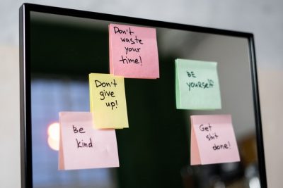 A photo of positive affirmations written on sticky notes which have been stuck on a mirror
