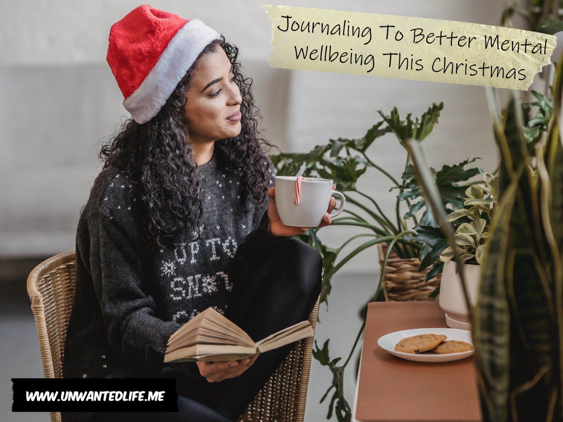 A photo of a Black woman in a Christmas jumper reading a book and drinking a hot chocolate to represent the topic of the article - Journaling To Better Mental Wellbeing This Christmas