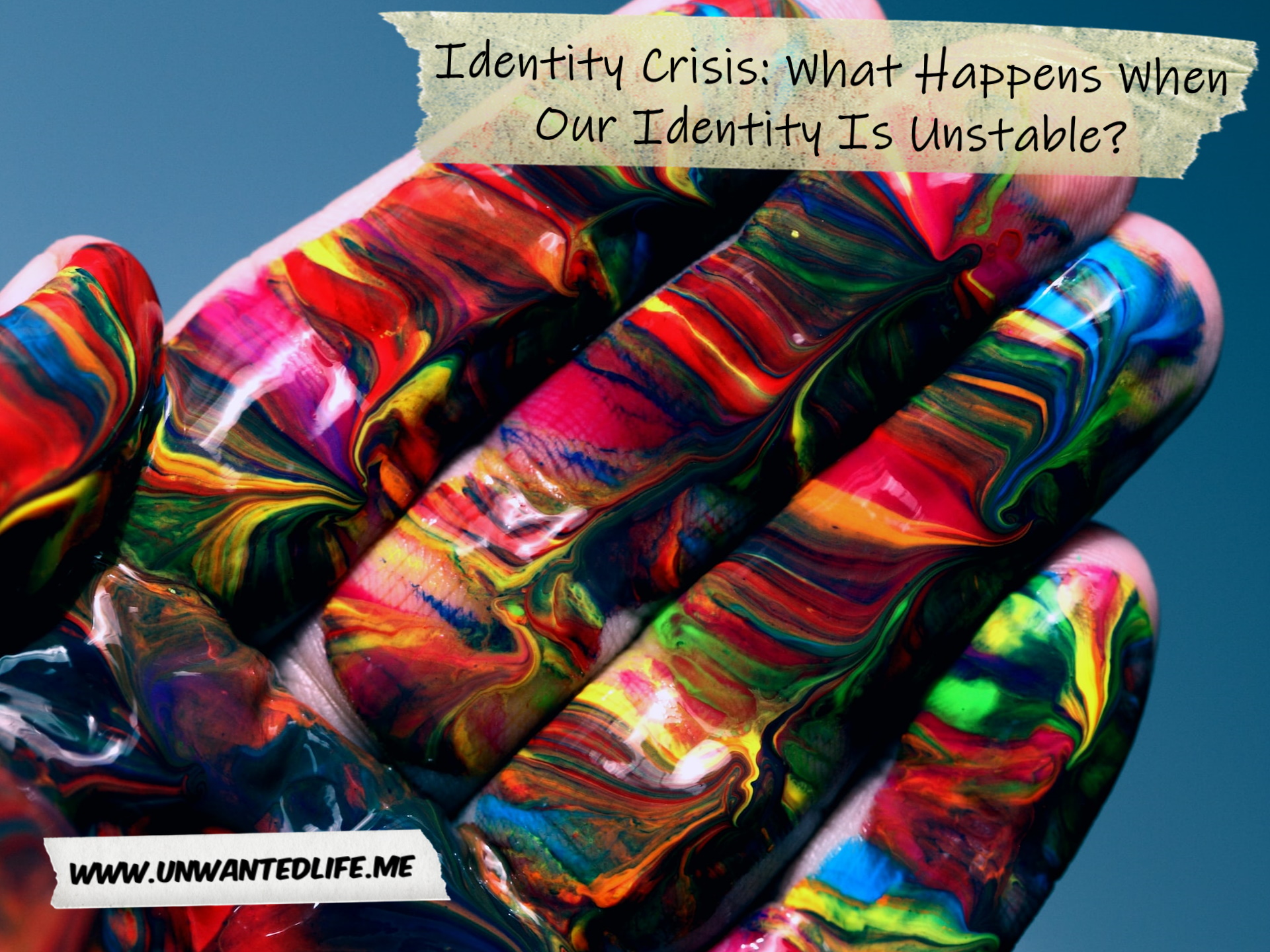 A photo of a White person's hand covered in a multitude of paint colours to represent the topic of the article - Identity Crisis: What Happens When Our Identity Is Unstable?
