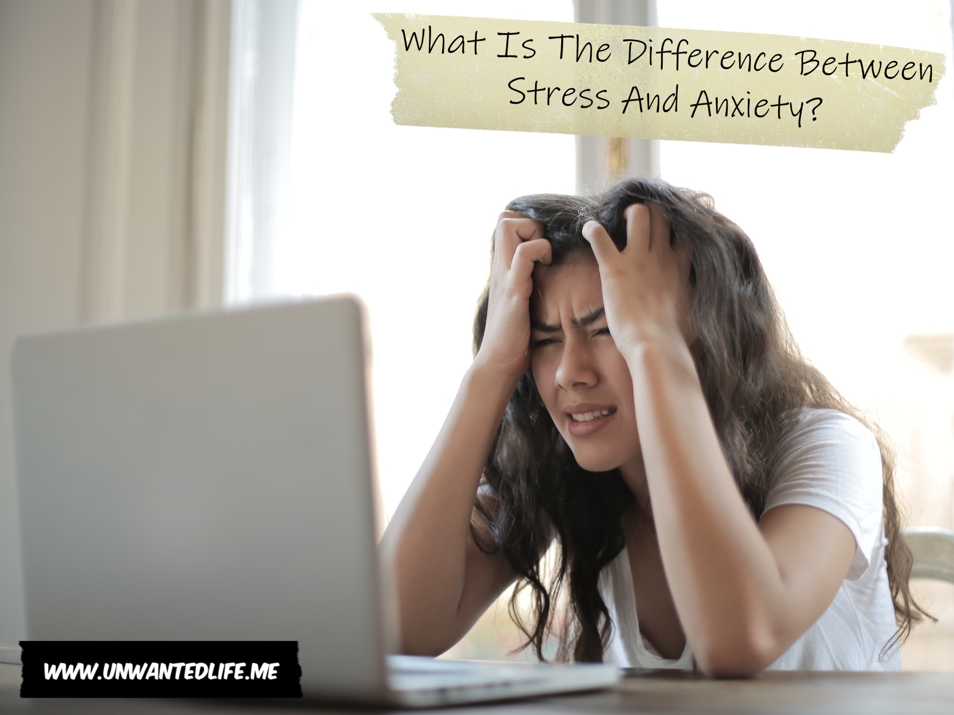 A photo of a woman looking anxious and stressed while leaning over their laptop to represent the topic of the article - What Is The Difference Between Stress And Anxiety?