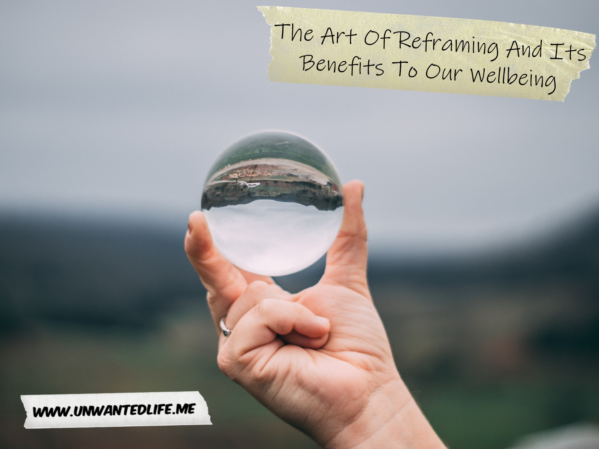 A photo of a White person holding a glass ball that flips the image upside down, granting a different perspective to represent the topic if the article - The Art Of Reframing And Its Benefits To Our Wellbeing