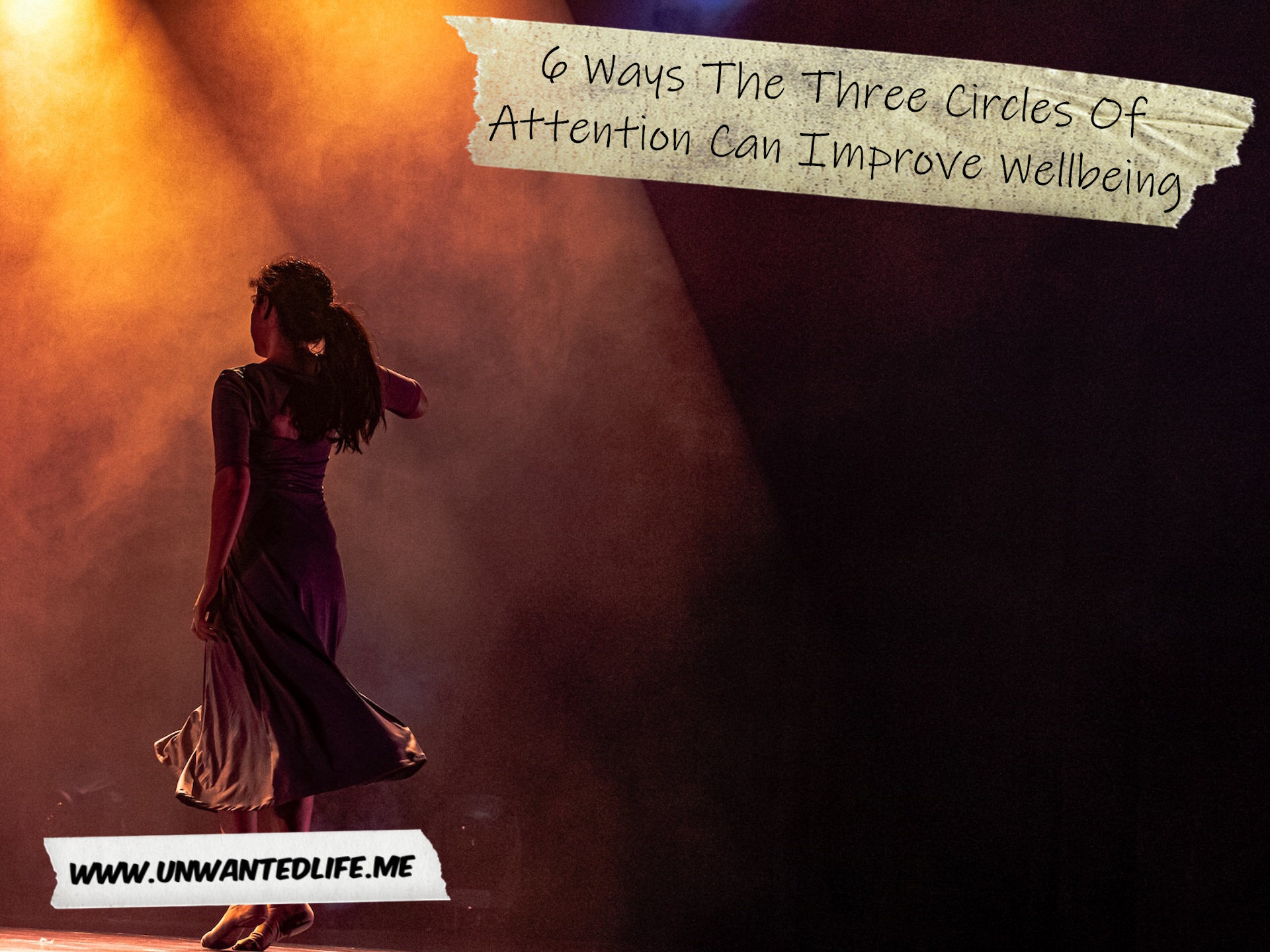 A photo of a woman standing on a dark stage lit up by a spotlight to represent the topic of the article - 6 Ways The Three Circles Of Attention Can Improve Wellbeing