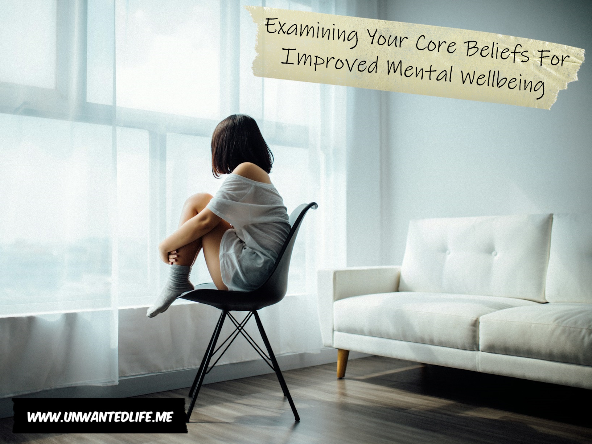 A photo of a woman sitting on a chair looking out of the window, comforting themselves, to represent the topic of the article - Examining Your Core Beliefs For Improved Mental Wellbeing