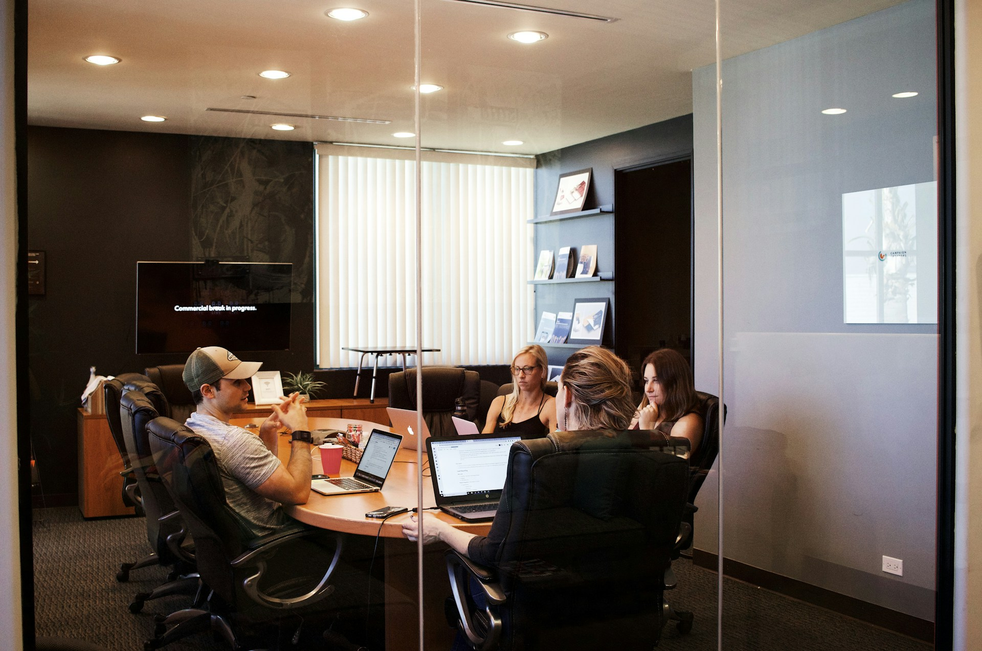 A photo of people sitting around a table in a meeting room to represent the topic of the article - Return To Work: My Experience With Crippling Re-entry Anxiety