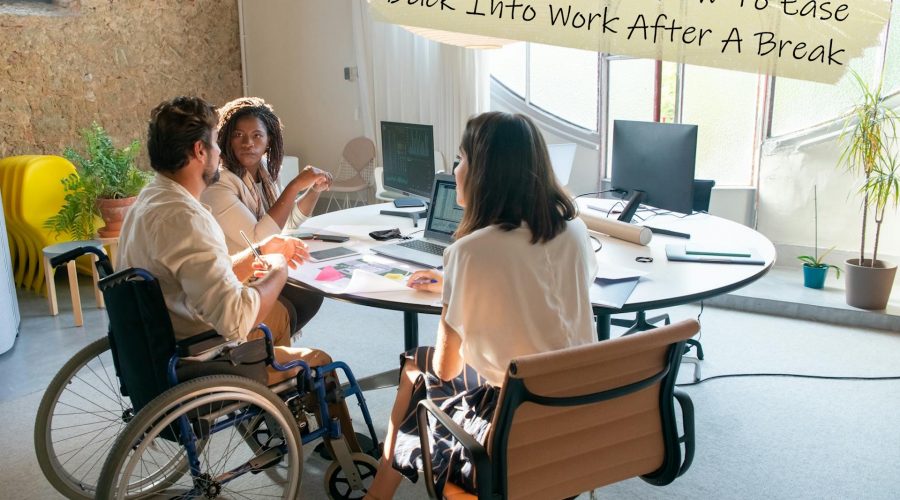 A photo of three people sitting around a work table, with one of those people being in a wheelchair to represent the topic of the article - Re-Entry Anxiety: How To Ease Back Into Work After A Break