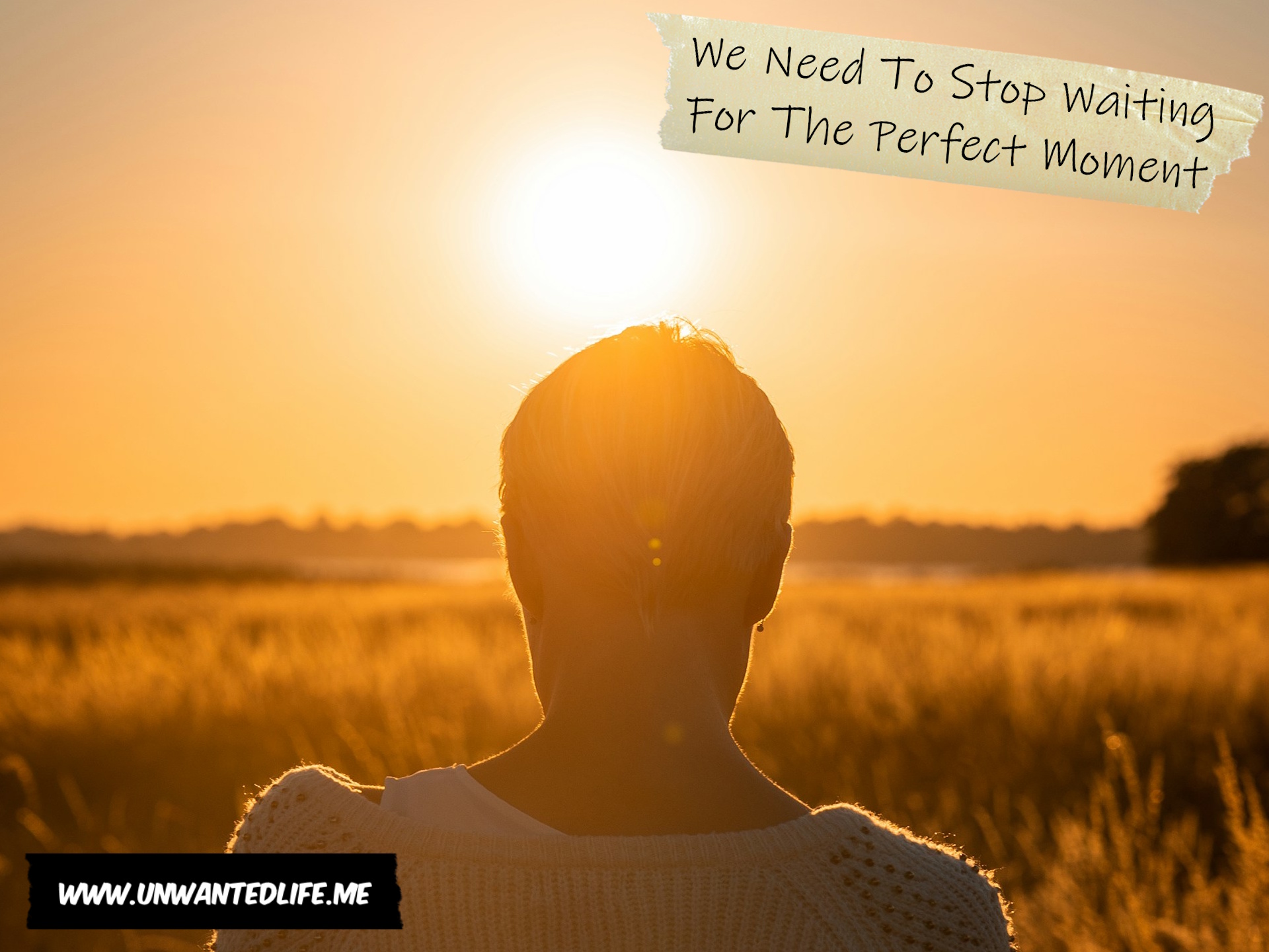 A photo of a woman sitting in a field looking at the sun set to represent the topic of the article - We Need To Stop Waiting For The Perfect Moment
