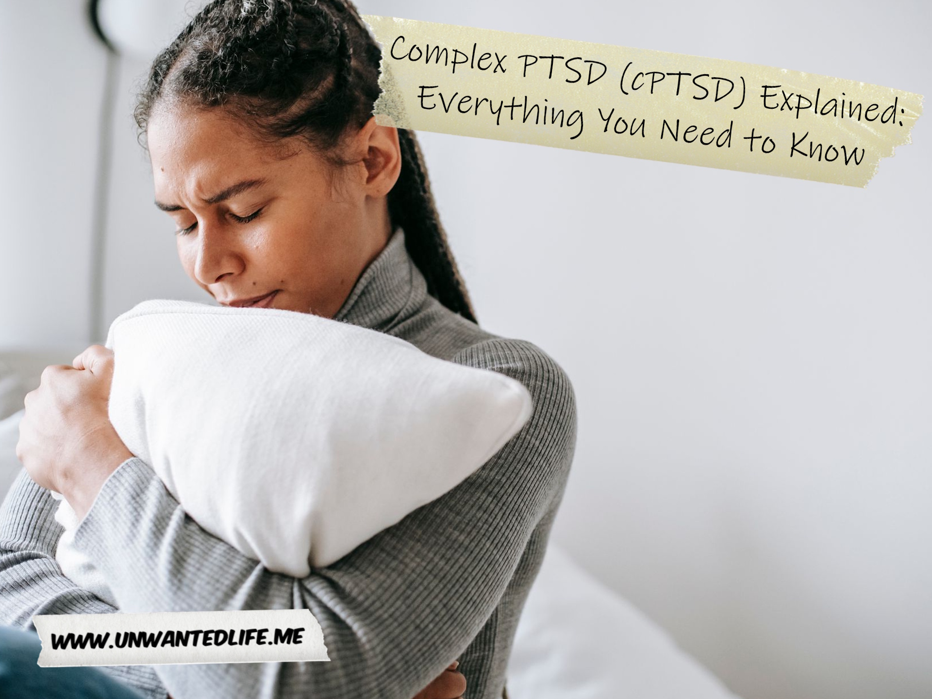 A photo of a woman of Black ethnicity looking upset and hugging a pillow to represent the topic of the article - Complex PTSD (cPTSD) Explained: Everything You Need to Know